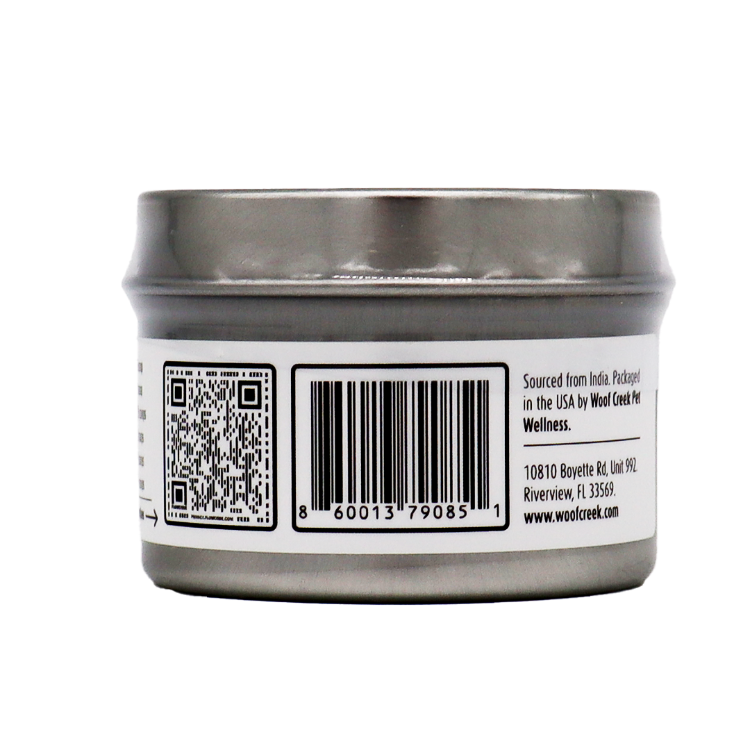 A silver tin can with a barcode, QR code, and printed text on its label. The text provides sourcing and packaging details along with a company address in Florida, USA. Specially designed for pet wellness, this product is labeled as Woof Creek | Ashwagandha Root Extract Powder for Dogs + Cats—a stress relief supplement for dogs and cats.