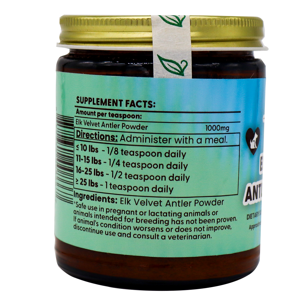 A 70g jar of Dr. Judy's Elk Velvet Antler Powder for Equines & Large Dogs features a green label displaying supplement facts, usage directions by pet weight, ingredients, and safety information. Designed as a joint support supplement to enhance dog mobility, the jar is topped with a gold lid and an attached seal adorned with leaf icons.