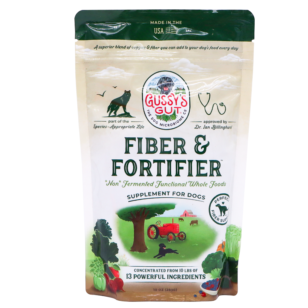 A beige 10oz bag of Gussy’s Gut | Fiber & Fortifier for Dogs features illustrations of a cat, dog, tractor, vegetables, and a farm scene. The packaging highlights its whole-food fiber blend and describes its benefits as a natural fiber supplement supporting optimal gut health in dogs.