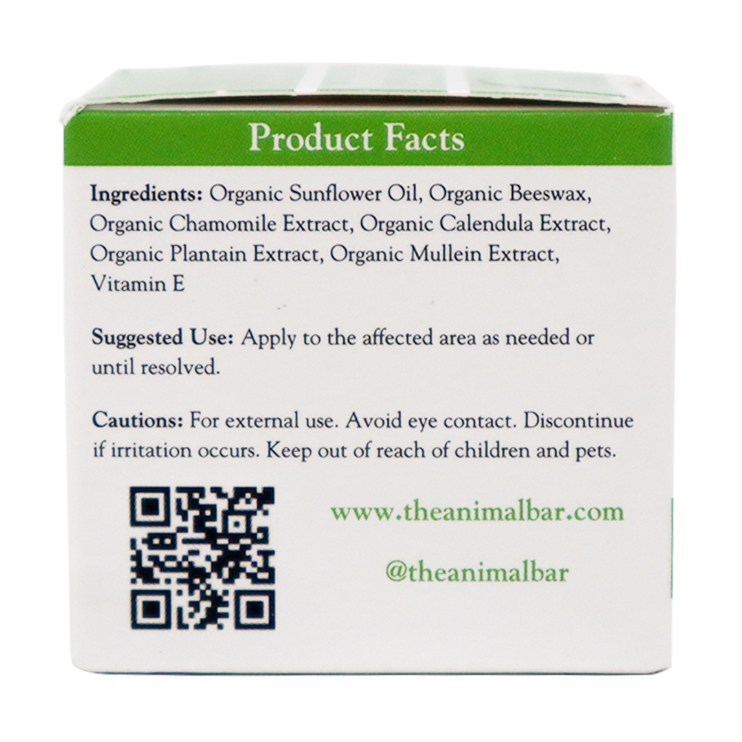 The box panel for The Animal Bar | Soothing Salve for Dogs & Cats – 2oz lists ingredients, suggested use, and cautions. It also features a QR code, website, and social media handle. Text appears in green and black on a white background.