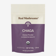 A pouch labeled Real Mushrooms | Organic Siberian Chaga Extract Powder – 60g, USDA organic, 60 servings. The cream and purple pack delivers potent chaga mushroom extract rich in beta-glucans for digestive health.