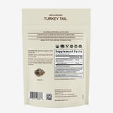 Back of a Real Mushrooms | Organic Turkey Tail Extract Powder - 45g bag displaying suggested use, warnings, supplement facts, and key product features. The text emphasizes that it is made with 100% organic turkey tail mushroom powder and contains beta-glucans. Ideal for mixing into tea, coffee, or smoothies.