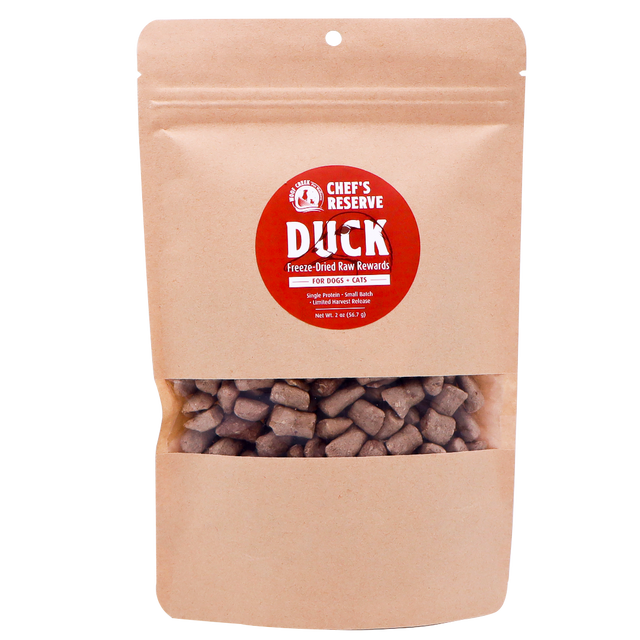 A brown resealable bag labeled Woof Creek Freeze-Dried Raw Duck Rewards | 2oz Pouch for Dogs + Cats, featuring visible brown treat pieces inside through a clear window. Perfect as high-value training rewards, these duck treats are irresistible for both dogs and cats.
