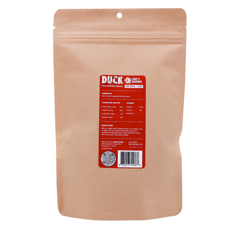 A brown resealable pouch labeled “Woof Creek Freeze-Dried Raw Duck Rewards | 2oz Pouch for Dogs + Cats” features a red and white label with nutritional information, a barcode, a QR code, and feeding instructions—making it easy for pet owners to offer their dogs or cats a high-value training reward or delicious treat.