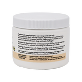 A white plastic container labeled "Wholistic Organics | Immune Boost - Ester-C" contains usage instructions, Vitamin C dosage for dogs and cats, immune support info, and manufacturer contact details.