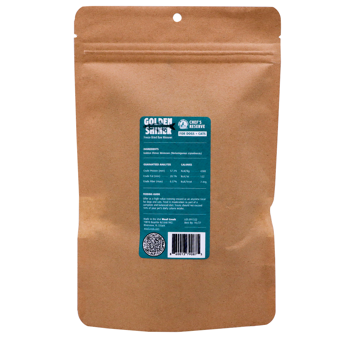 A brown resealable pouch with a blue label displaying product information for Woof Creek Golden Shiner Minnows | 1.5oz Pouch for Dogs + Cats, perfect as a nutritious training reward for your pets. The ingredients and nutritional details are listed on the label.