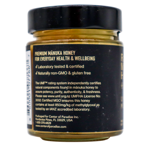 Back label of a Center of Paradise | RAW MANUKA HONEY UMF 20+ MGO 850+ jar detailing its laboratory certification, non-GMO and gluten-free status, MGO 850+ content, and UMF rating information.