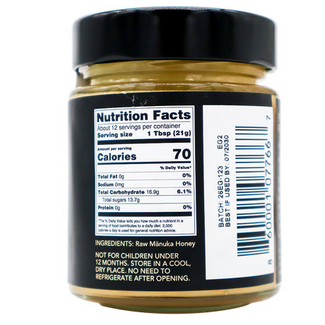 A close-up of a Center of Paradise | RAW MANUKA HONEY UMF 20+ MGO 850+ jar label showing Nutrition Facts, including 70 calories per serving, the ingredients list, and a barcode.