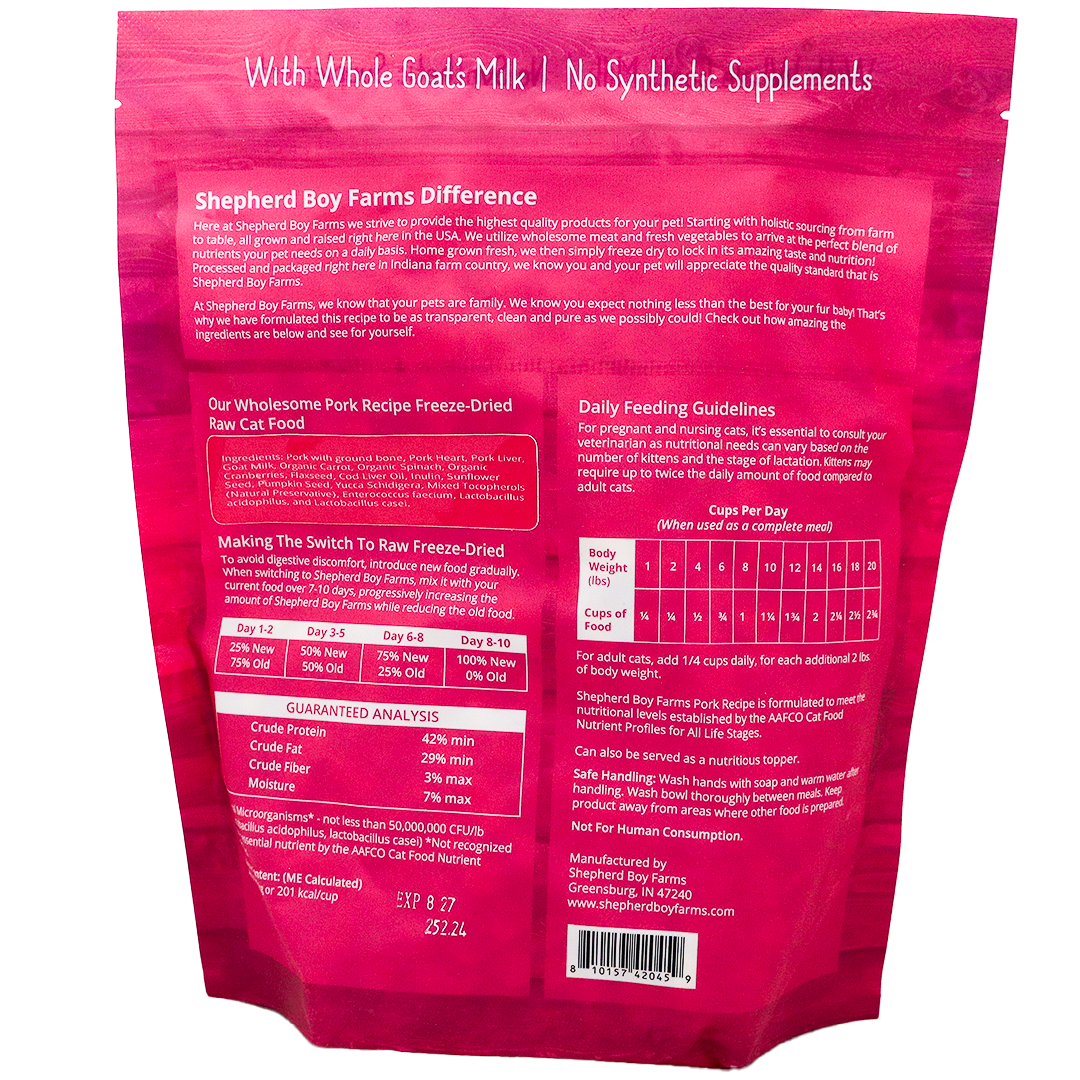 Back of a pink Shepherd Boy Farms | Pork Recipe for Cats - 14oz package displaying feeding guidelines, product description, ingredients list, guaranteed analysis, and contact information. The text highlights the use of whole goat's milk and the absence of synthetic supplements, emphasizing a grain-free cat food formula that supports natural nutrition.