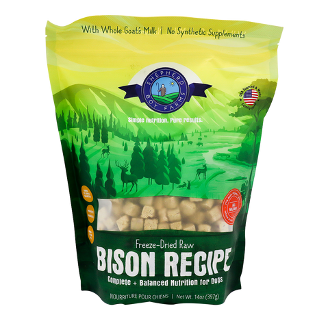 A green and yellow bag of Shepherd Boy Farms Freeze-Dried Bison Recipe (14oz) dog food, featuring a natural landscape with animals and trees. This grain-free recipe includes goat’s milk, no synthetic supplements, and is AAFCO approved.