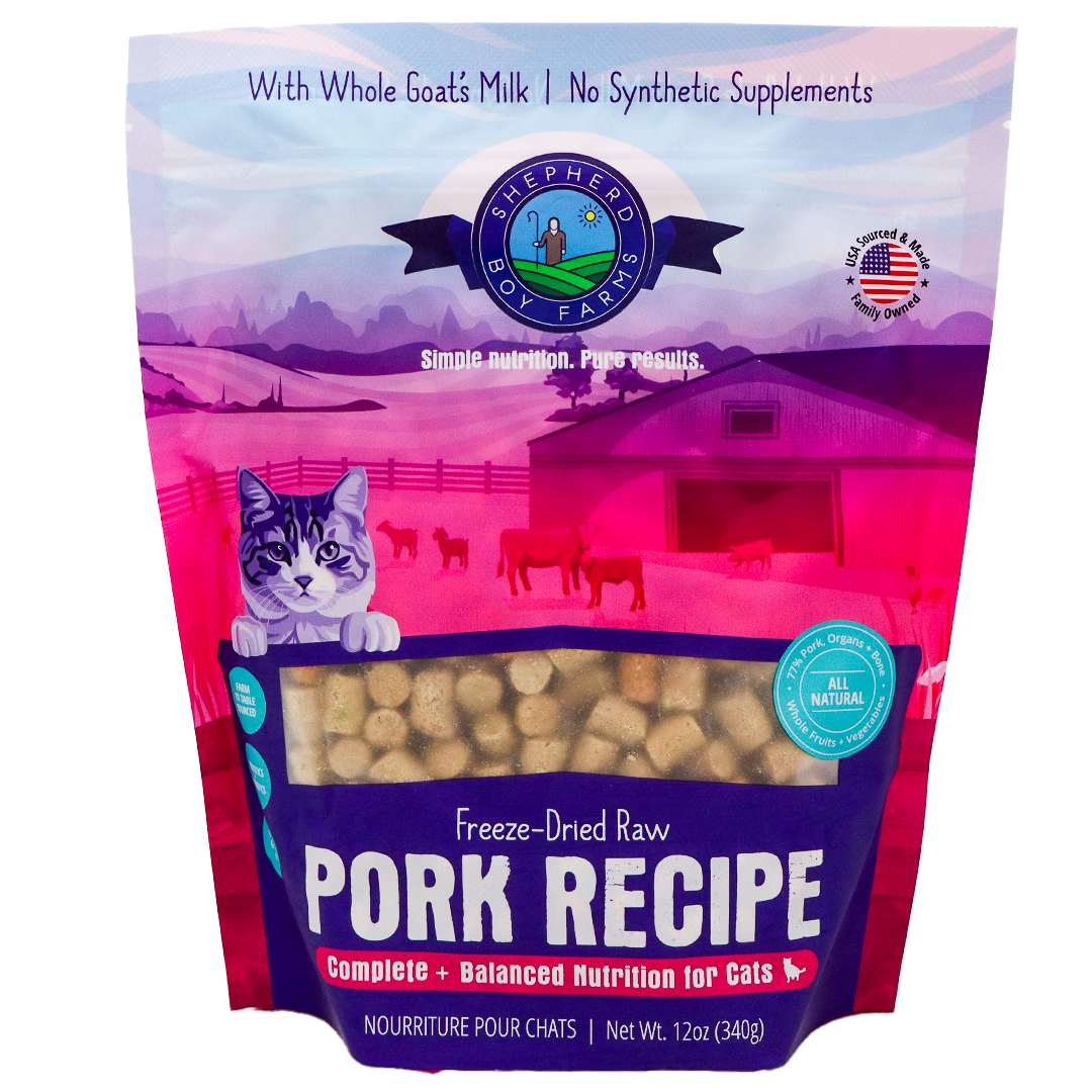 A 14 oz (396 g) bag of Shepherd Boy Farms Pork Recipe for Cats features freeze-dried raw pork, a cartoon cat with a farm background, and text highlighting goat's milk and balanced nutrition for cats. This grain-free cat food provides wholesome nourishment in every serving.