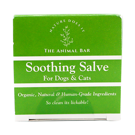 A green and white box labeled “The Animal Bar | Soothing Salve for Dogs & Cats - 2oz” features text emphasizing its organic, natural, human-grade ingredients with the slogan “So clean it’s lickable!” alongside a simple botanical graphic.