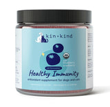 A jar of kin+kind Urinary Tract with Antioxidant Boost supplement for dogs and cats, crafted from USDA organic pet supplements and featuring powerful superfoods like blueberry and cranberry to support urinary tract health. This 8 oz container has a blue label, a white lid, and is designed for your pet’s well-being.